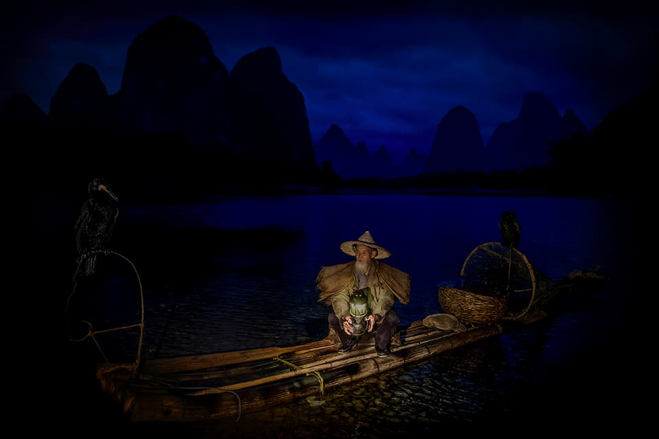 A mesmerizing blue hour scene captures the essence of tranquility. Boats rest peacefully on glassy waters, mirroring the dramatic sky above. This image invites you to pause and breathe in the calm of a perfect evening.