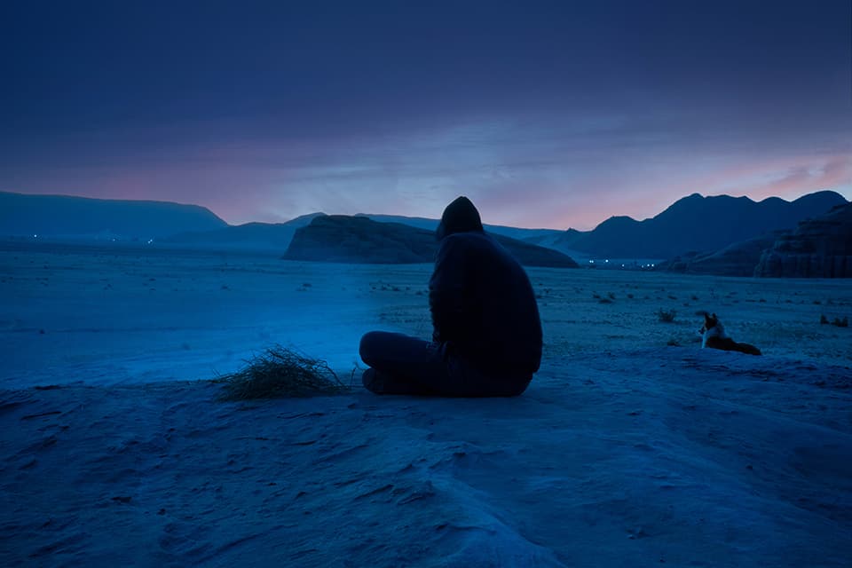 A lone figure contemplates the vast expanse of a desert twilight. This evocative scene captures the profound beauty of solitude, inviting the viewer to explore their own inner landscapes and find peace in quiet moments.