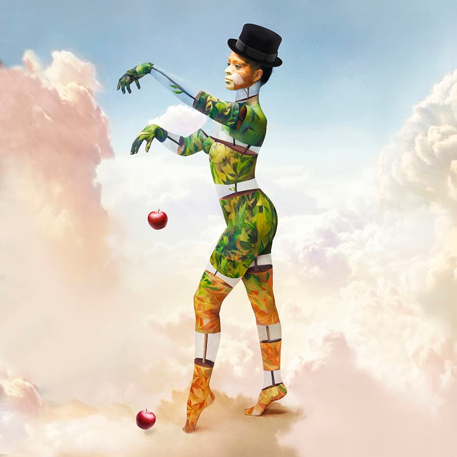 A whimsical figure painted in vibrant leaf patterns stands against a cloudy sky. Dressed in autumnal colors and a top hat, the figure appears to be manipulating apples with invisible strings. This surreal image blends elements of nature, magic, and human artistry in a dreamlike scene.